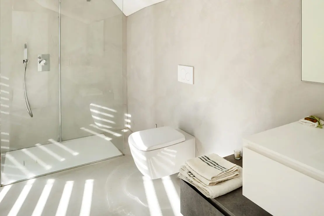 Salle de bain avec sol et murs en béton ciré de couleur claire à Vannes.